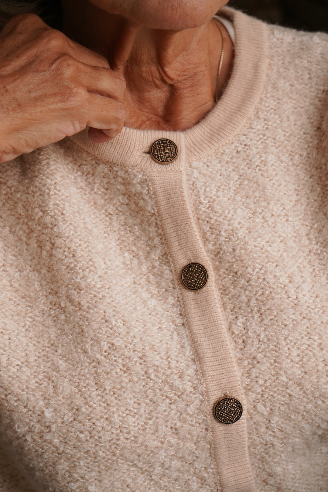 Close-up of a beige cardigan with button details