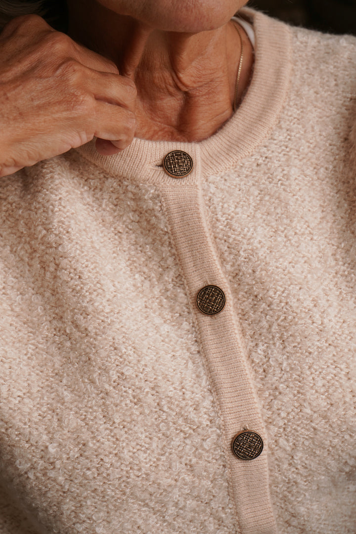 Close-up of a beige cardigan with button details