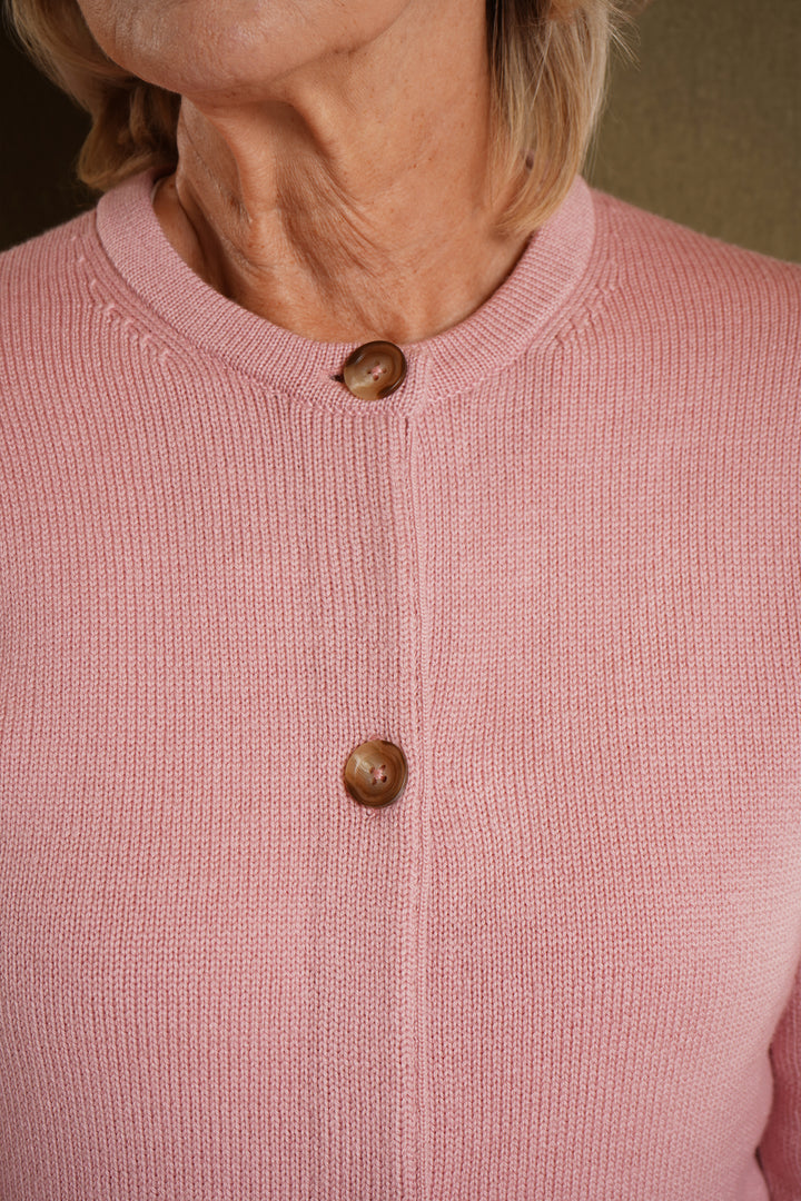 Close-up of a pink cardigan with buttons on a blurred background