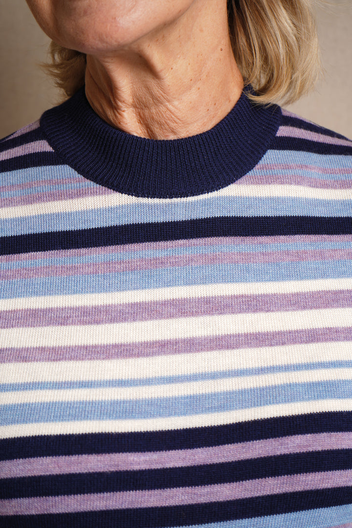 Close-up of a person wearing a striped sweater with blue, purple, and white horizontal stripes.