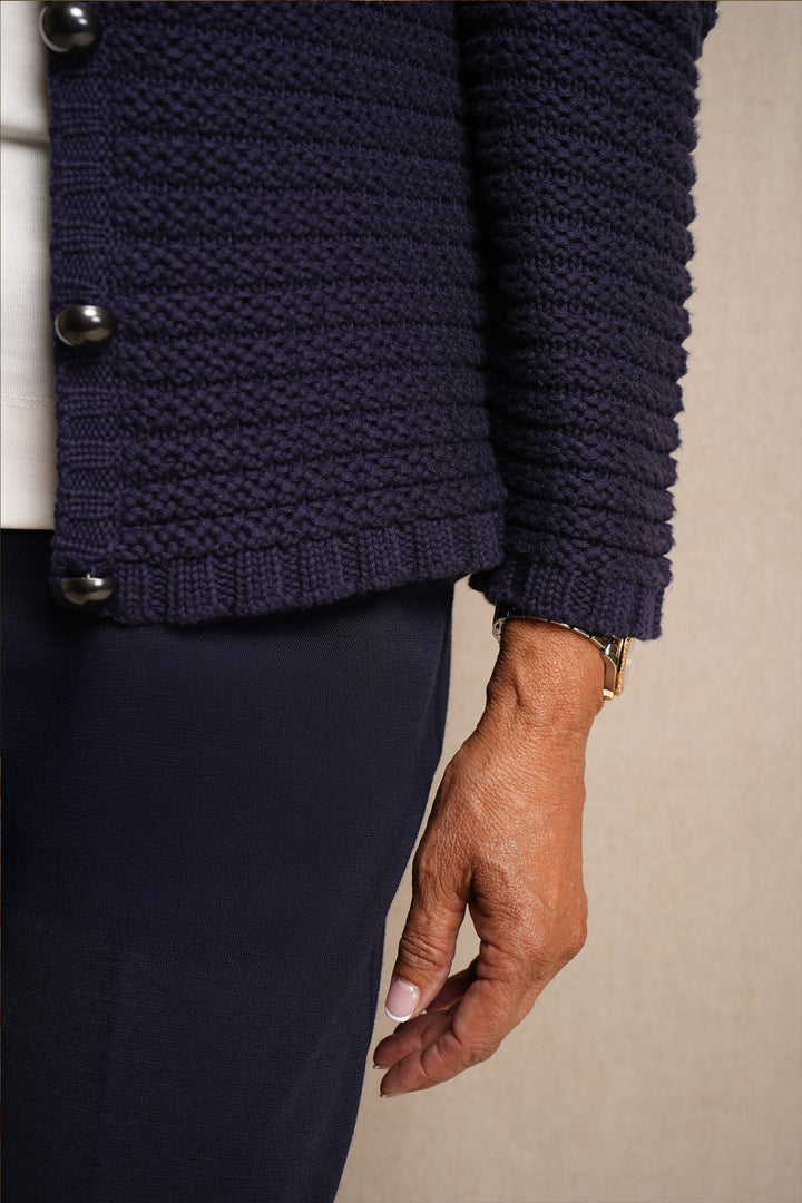 Navy  knitted cardigan with buttons on a neutral background