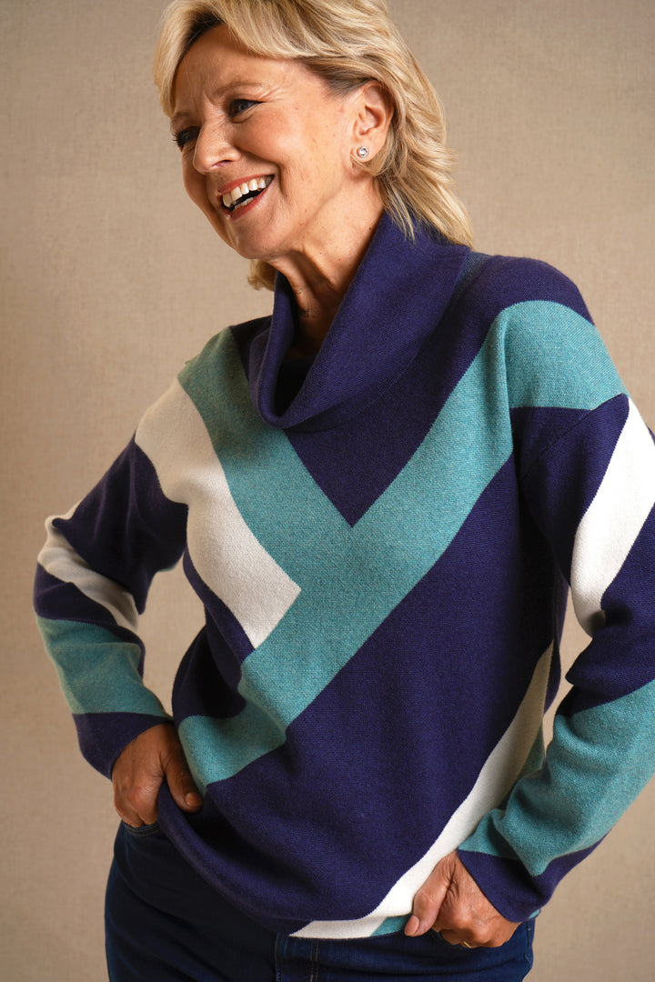 Woman wearing a colorful sweater with a neutral background